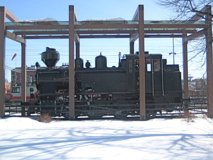 An old 0-8-0 Steamer sits under a glass roof near the staton at  Jyväskylä 